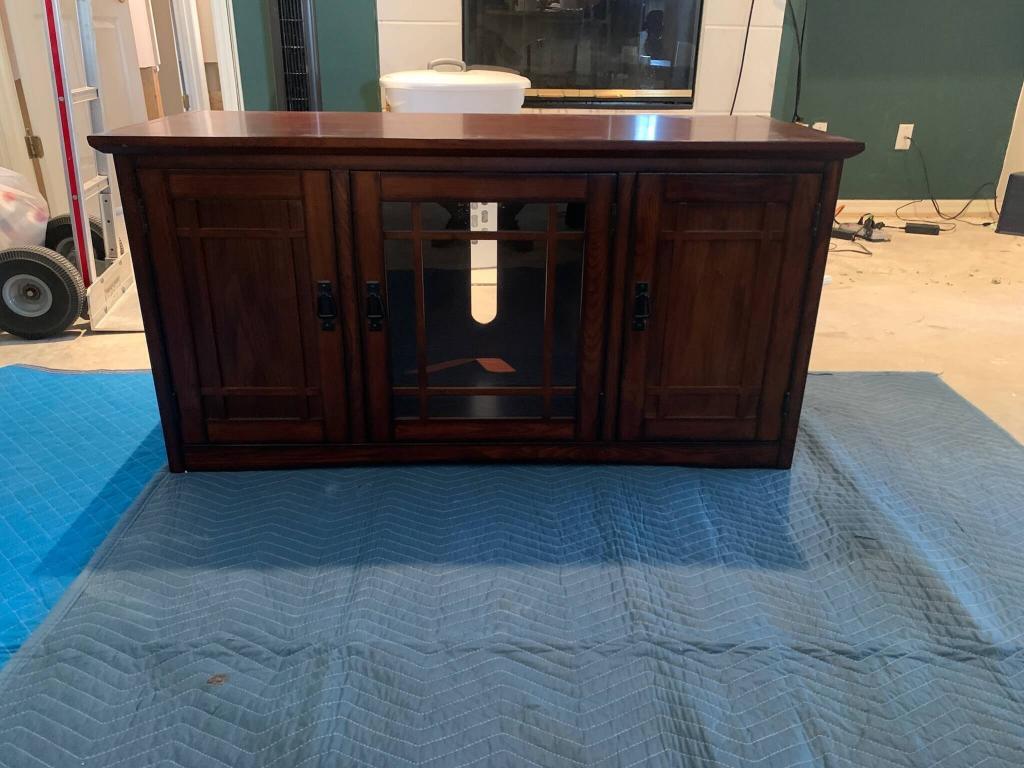 Dark wood dresser set on a blue protective mat before wrapping