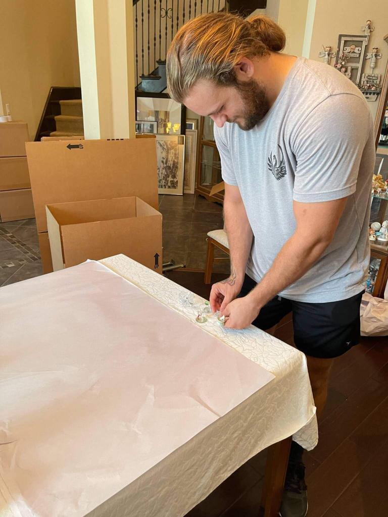 Black Swan Moving team member wrapping a delicate item in packing paper