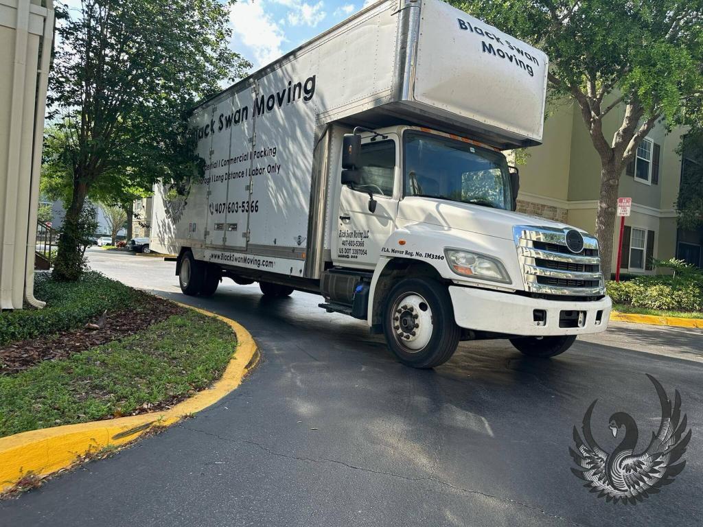 Black Swan Moving truck parked at an apartment complex.