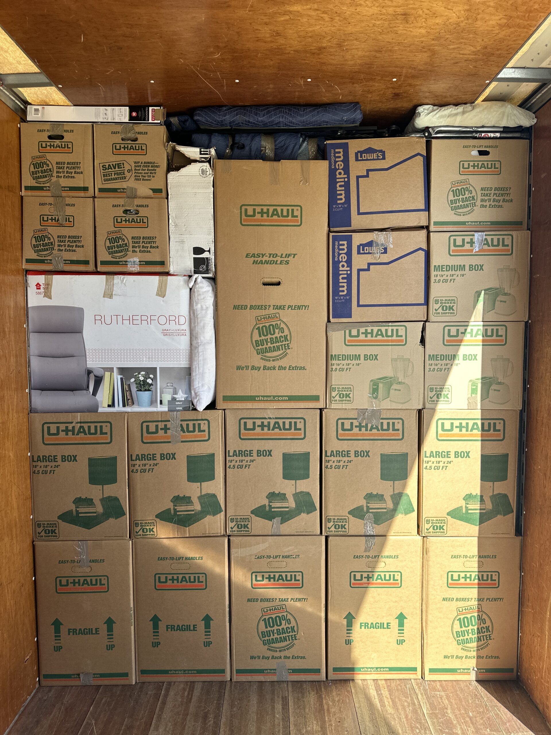 Commercial furniture and boxes organized inside a Black Swan Moving truck