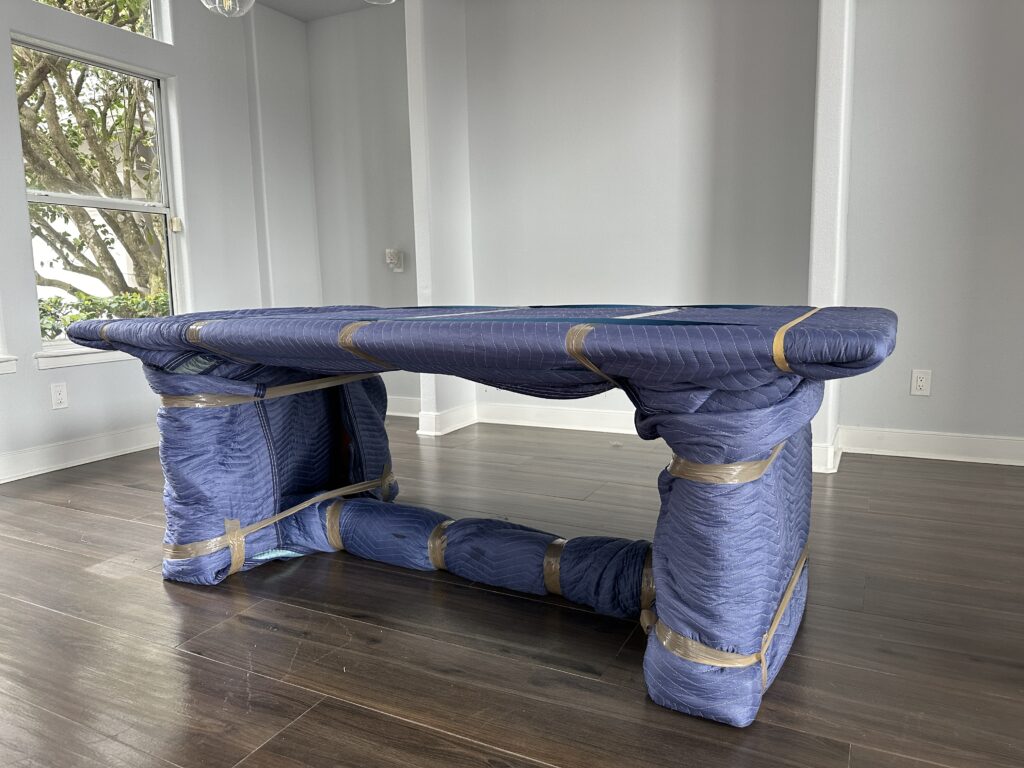 Tabletop and legs covered with protective moving blankets