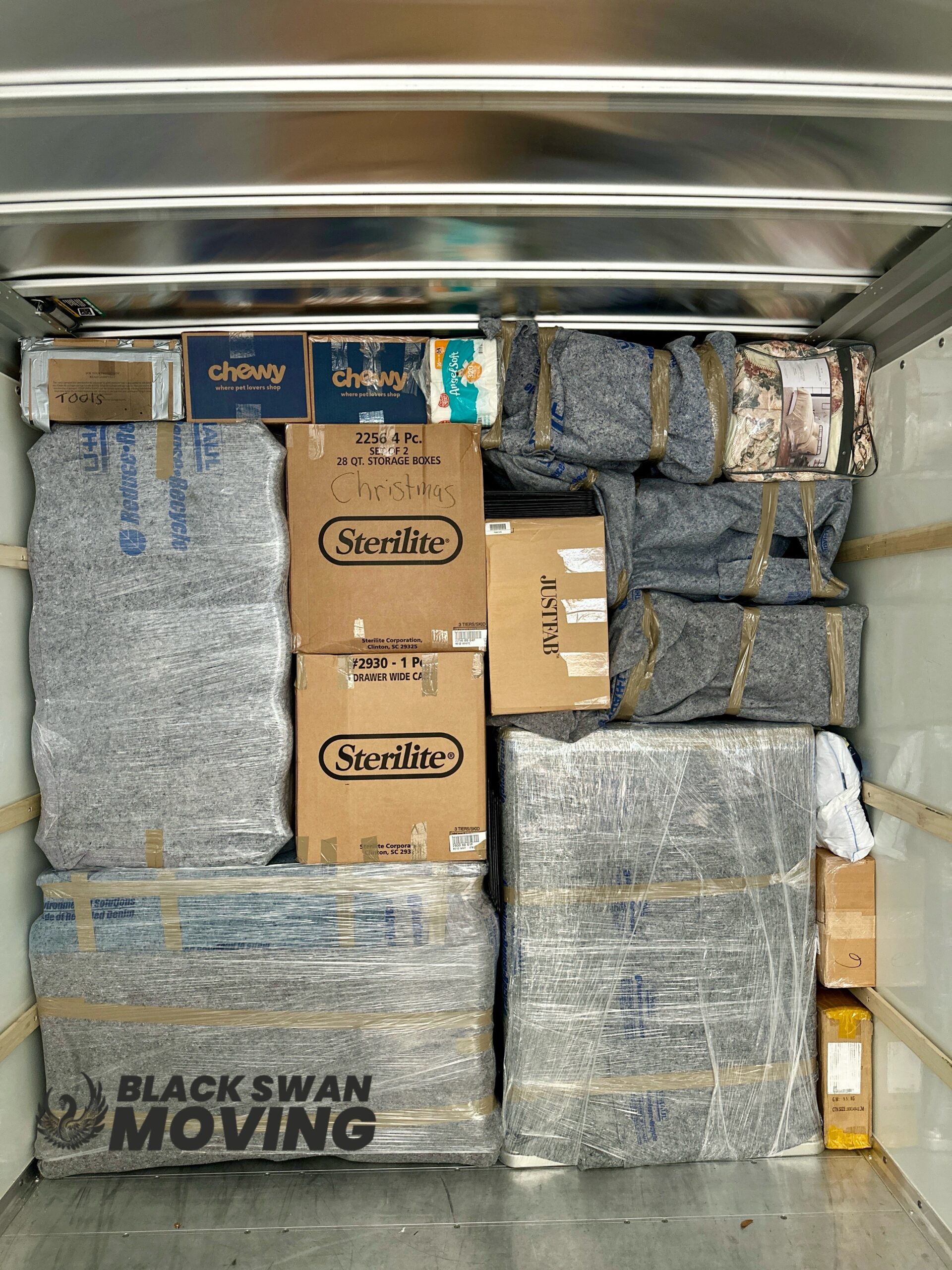 Black Swan Moving truck carefully packed with wrapped furniture and moving boxes