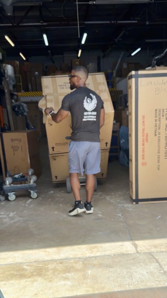 Black Swan mover loading boxes and boxed furniture in a warehouse