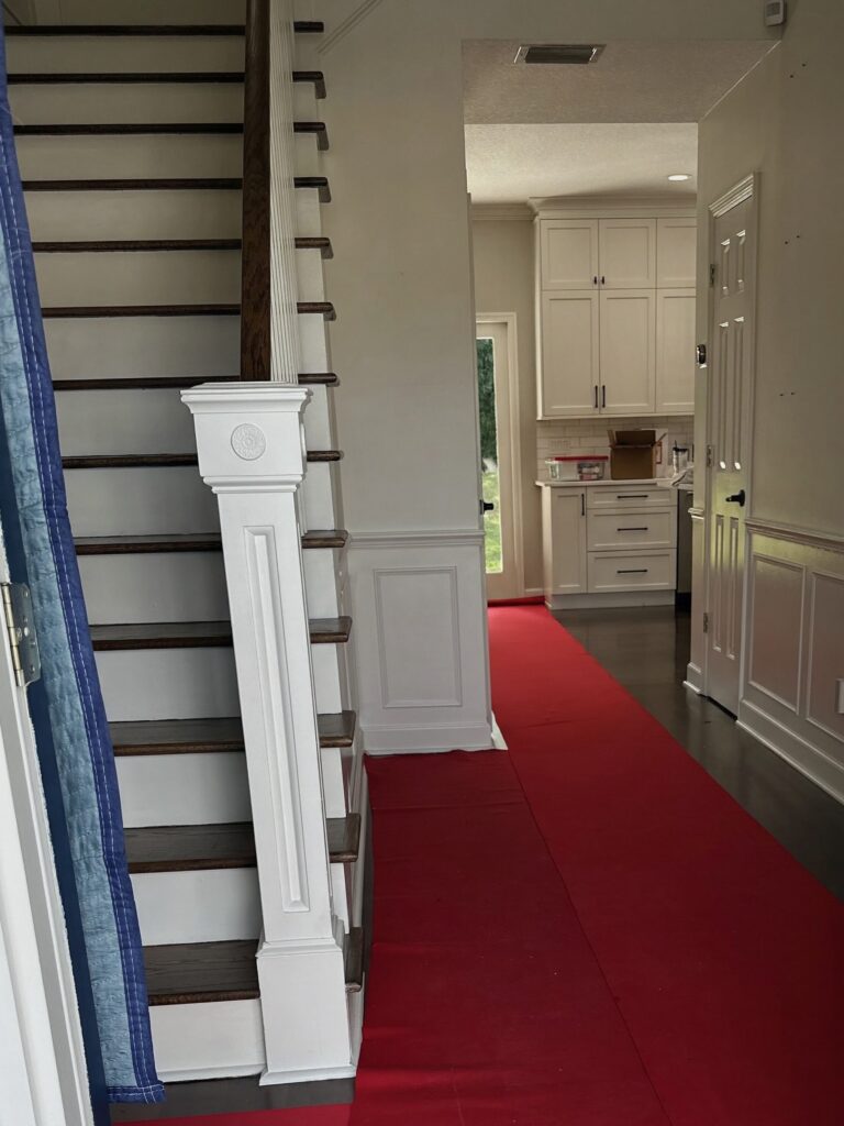 Red floor protection runners on hardwood floors and stairs during a Black Swan move