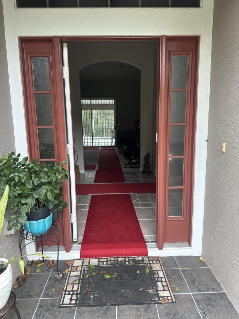 Red floor runner laid through a home's front door to protect the floors during a Black Swan Moving job