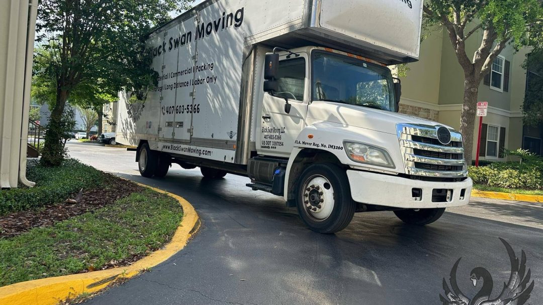 Black Swan Moving truck parked at an apartment complex.